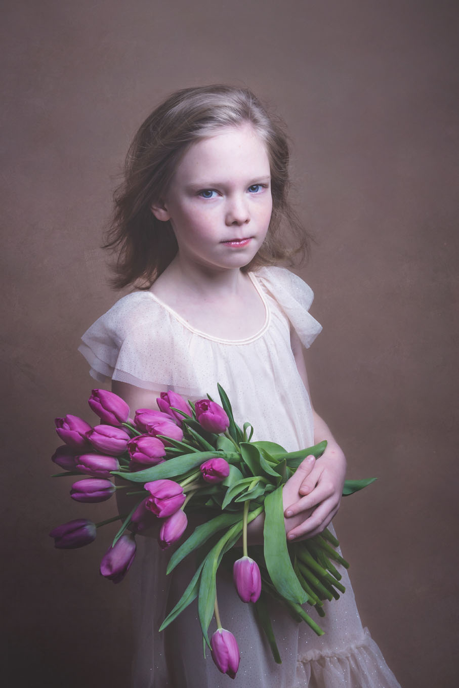 Portrait of a little girl in a studio with backdrop and lighting equipment
